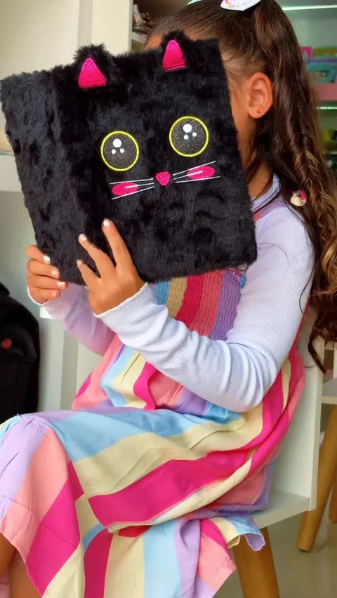 Post: menina segurando um caderno de gatinho